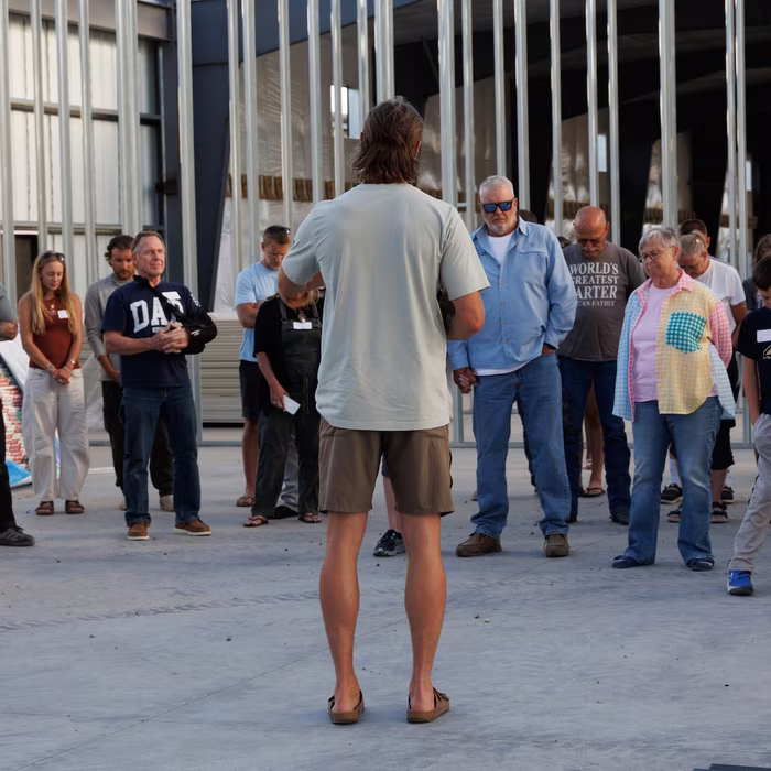 A leader speaking to a circle of church members inside the building