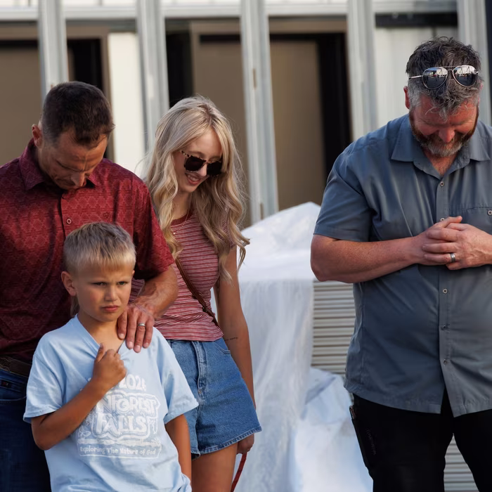 A family praying together at the building site